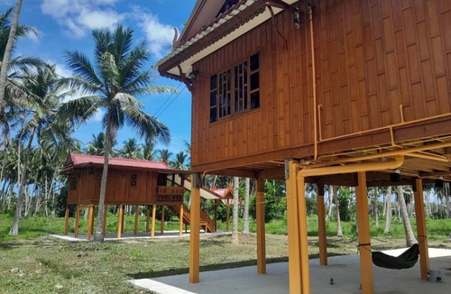 Thong Chai House | Traditional Thai wooden house on stilts set in a coconut orchard near the beach